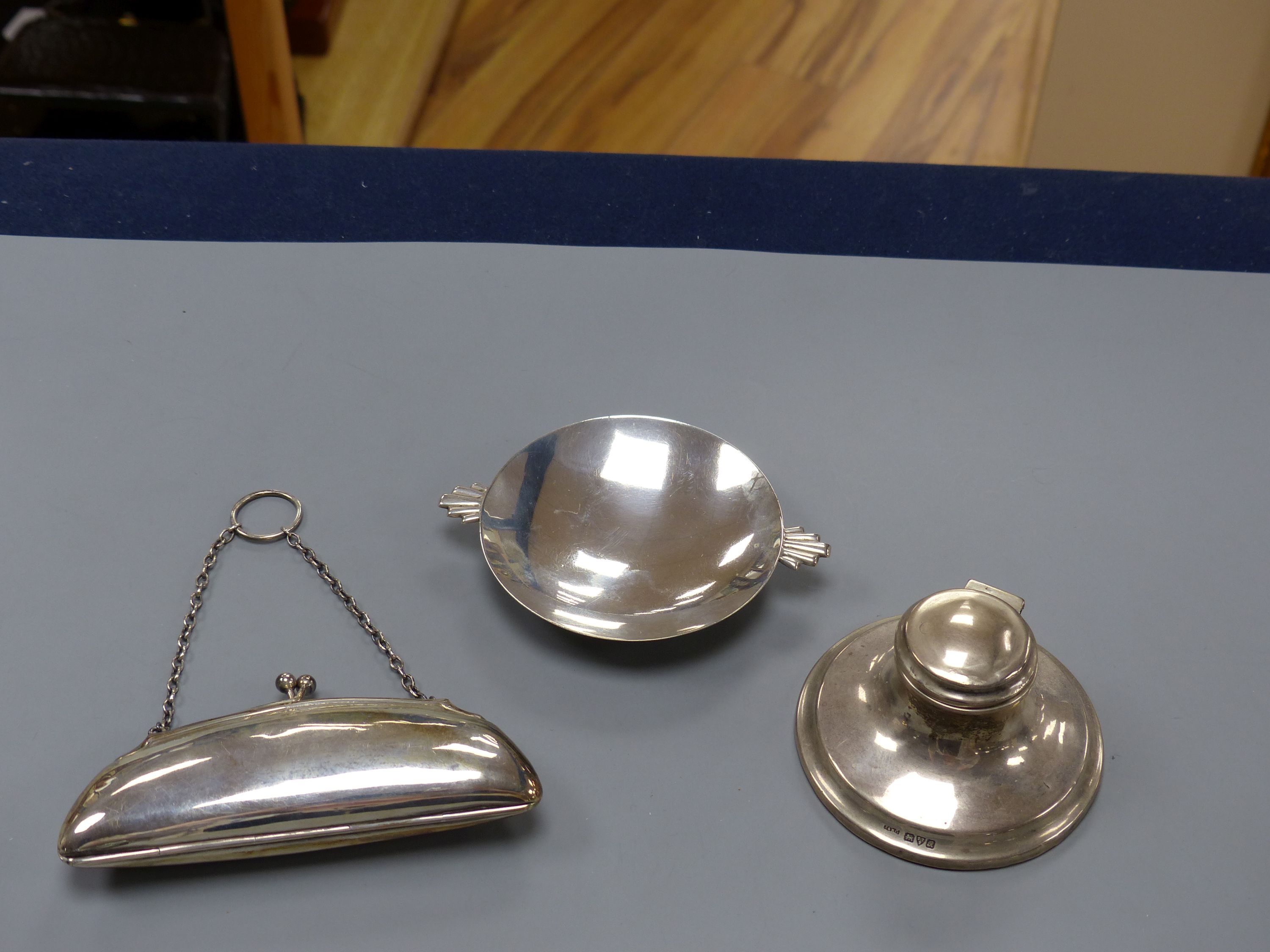 An Art Deco silver nut dish with fan shaped handles, Birmingham, 1934, 11.5cm, a silver purse and a silver inkwell.